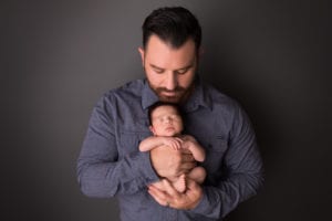 Portland Newborn Photographer dad holding newborn upright