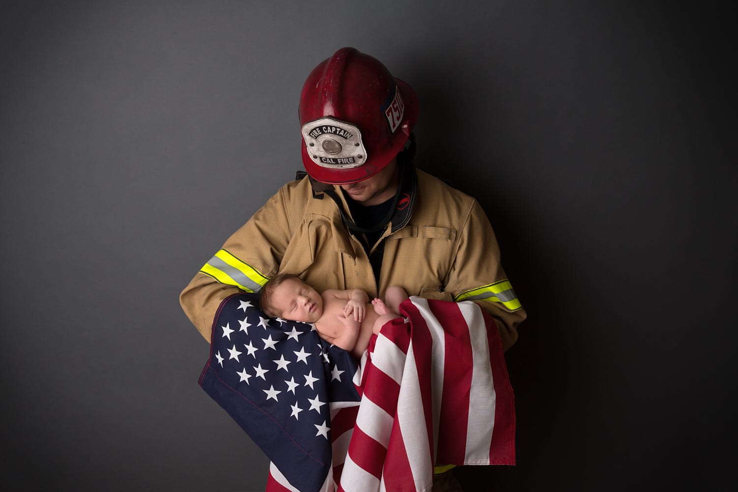 Portland Newborn Photographer firefighter holding newborn in American flag