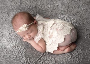 Portland Newborn Photographer baby girl curled up on tummy in dress