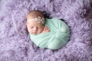 Portland Newborn Photographer baby swaddled in mint on lavender rug