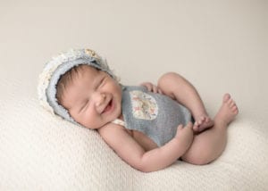 Portland Newborn Photographer baby laughing with blue bonnet on