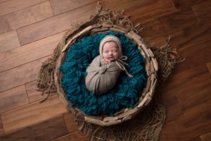 Portland Newborn Photographer Baby swaddled with teal and gray in driftwood bowl
