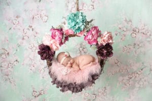 Portland Newborn Photographer baby in multicolored floral swing