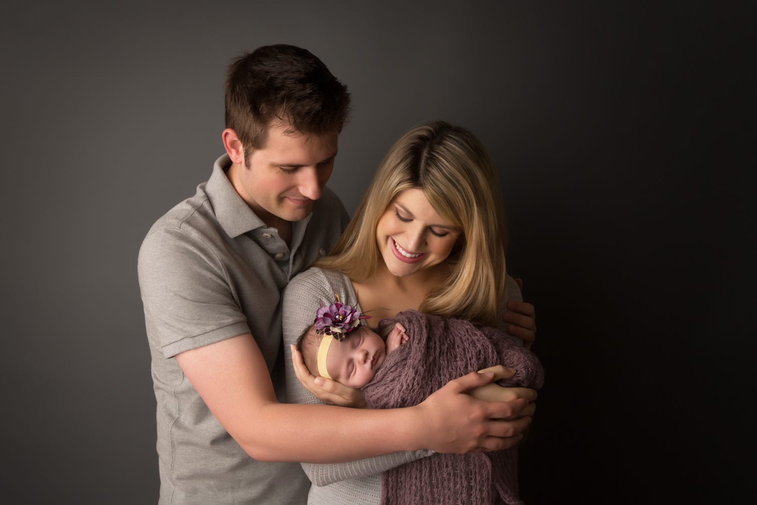 Portland Newborn Photographer parents holding swaddled newborn girl