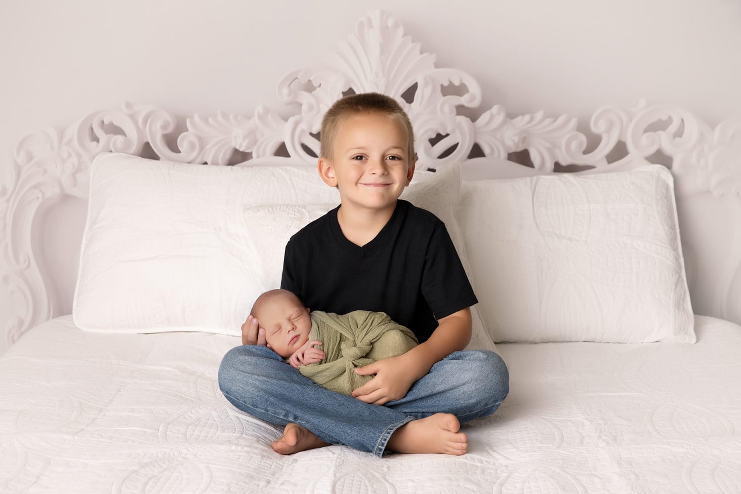 Portland Newborn Photographer sibling holding baby on bed